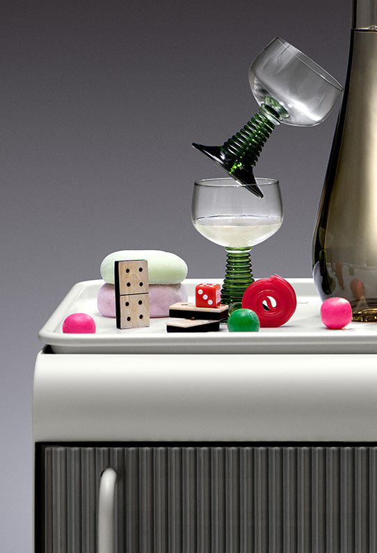 Drinking glasses and a number of small household items resting on top of the Rocco Fridge in white.