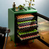 Opened Green Rocco fully stocked with cans with flowers, limes and a shaker on top. 