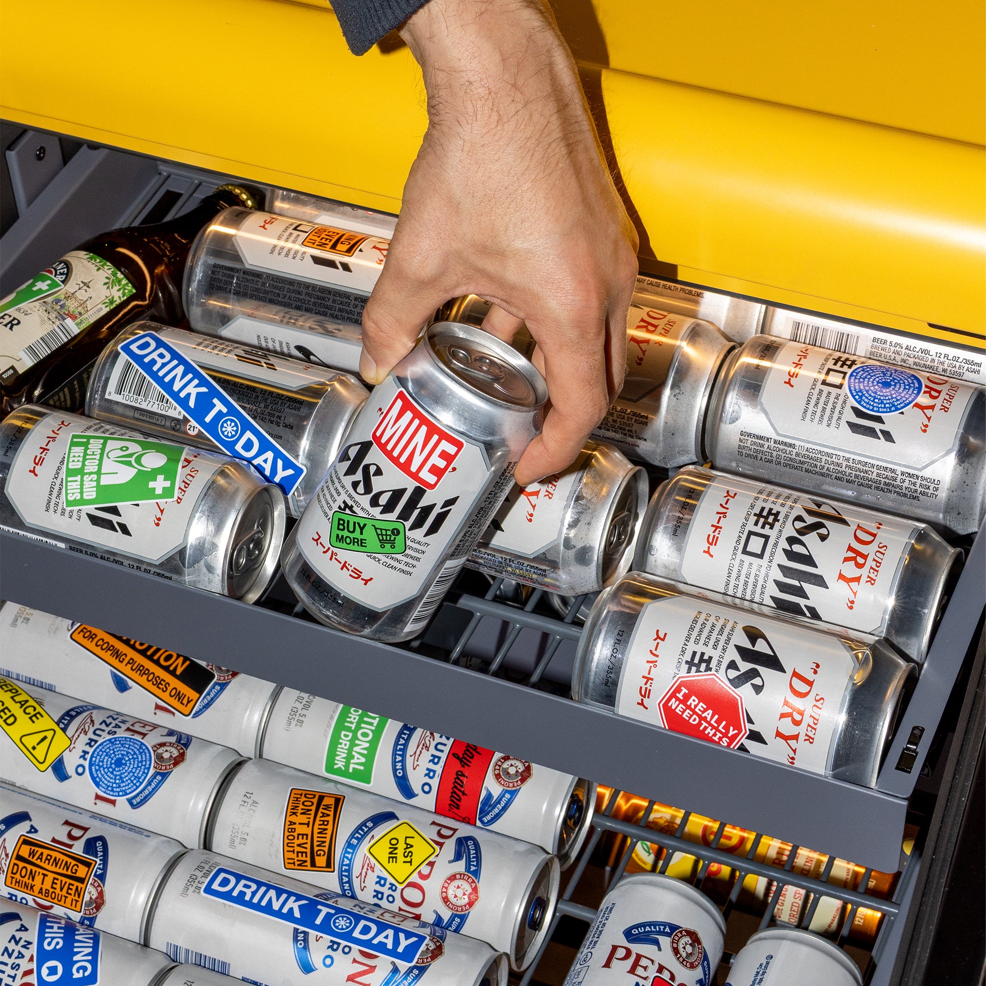 Man grabbing a can with sticker on it out of a Yellow Rocco fridge