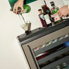 Person pouring drink from a shaker on the bar tray on top of a Graphite Rocco Fridge.