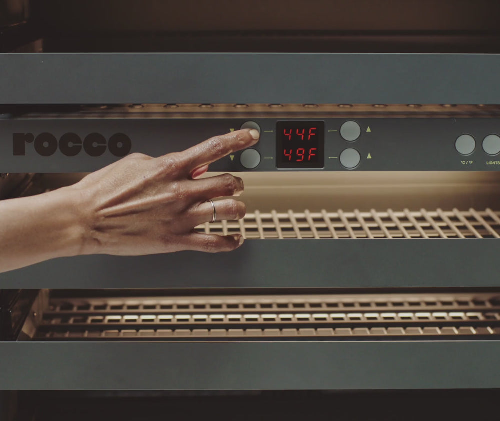 A user adjusting the temperature of a Rocco Fridge on the control panel.